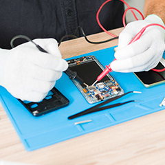 Técnico realizando assistência técnica no reparo da placa mãe do celular