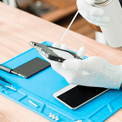 Técnico realizando a limpeza dos conectores para troca de bateria no smartphone